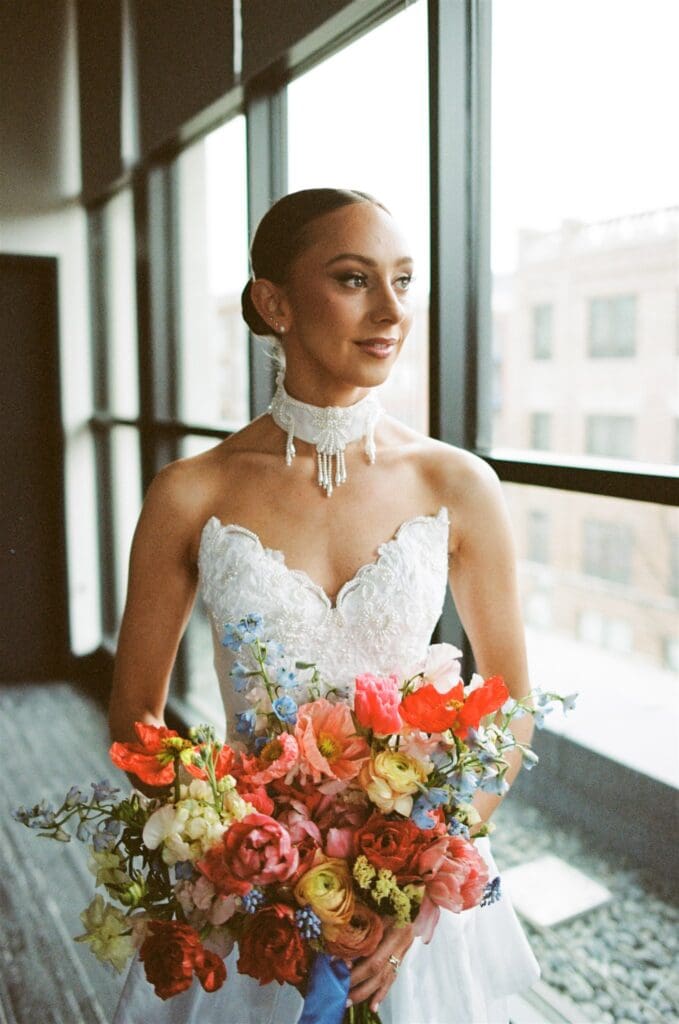 Bride getting ready wearing her bridal gown holding a bouquet