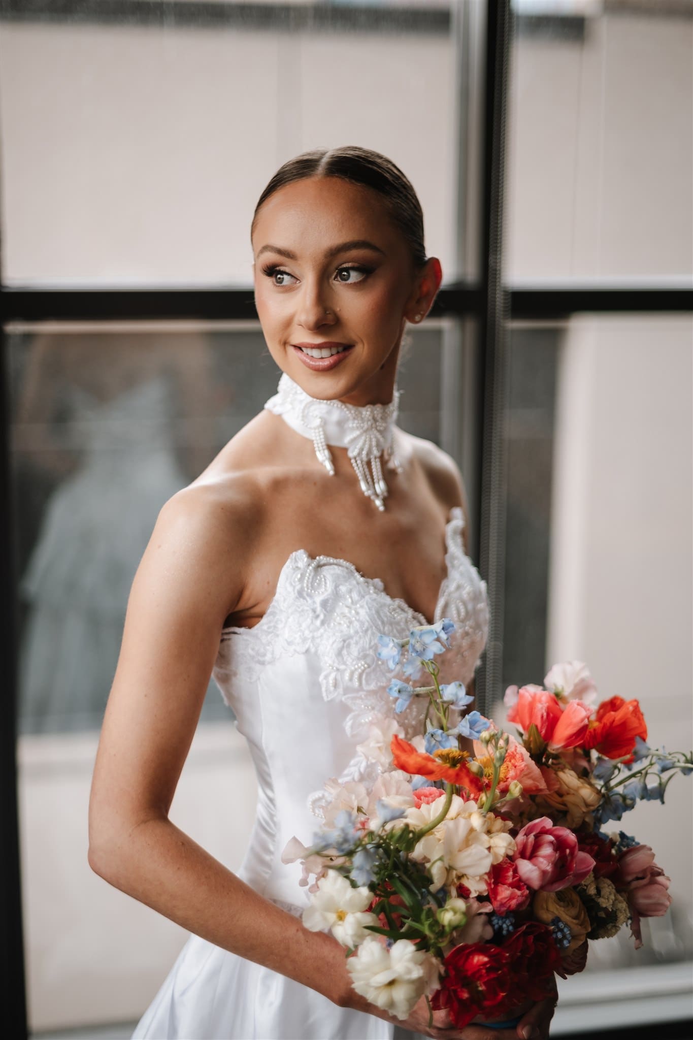 Bride getting ready wearing her bridal gown holding a bouquet