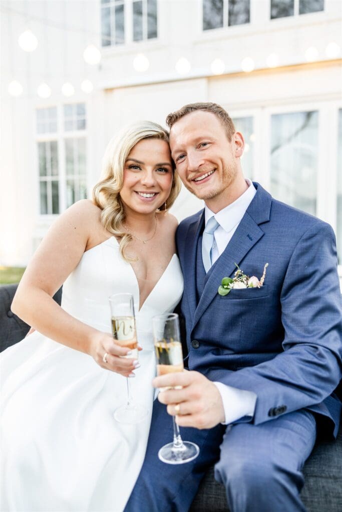 Bride and groom holding champagne glasses posing for the camera