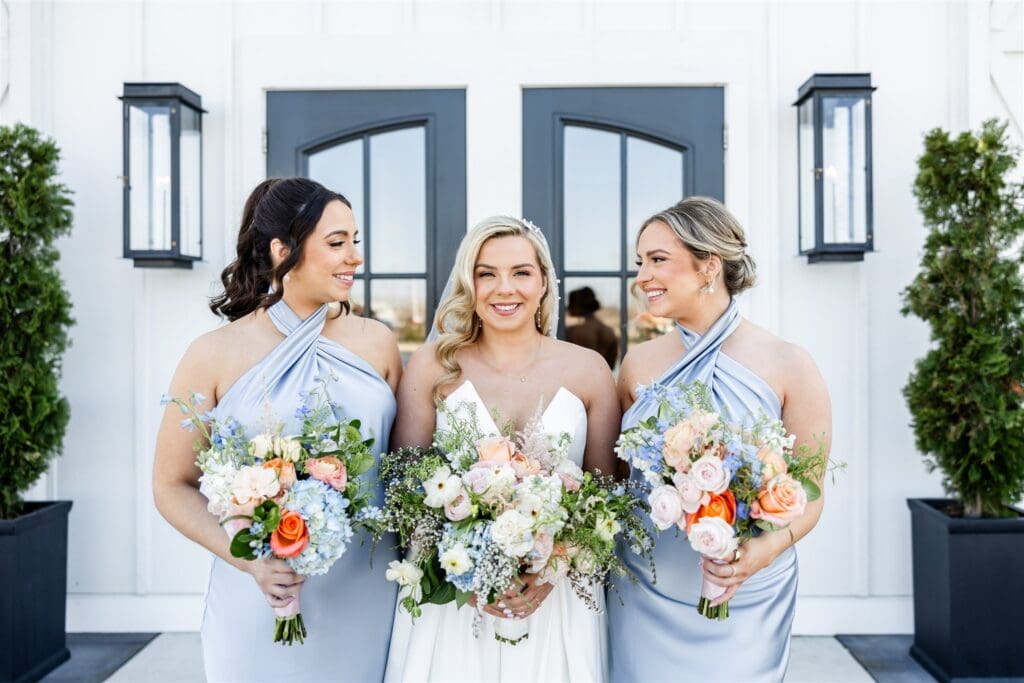 Bride with her bridesmaids holding bouquet of flowers