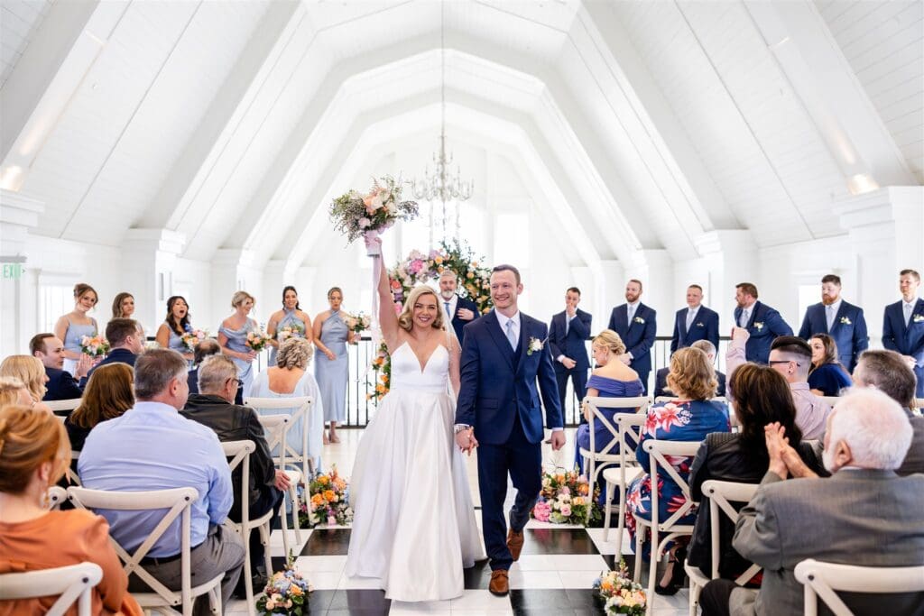 Bride and groom walking down the aisle holding hands