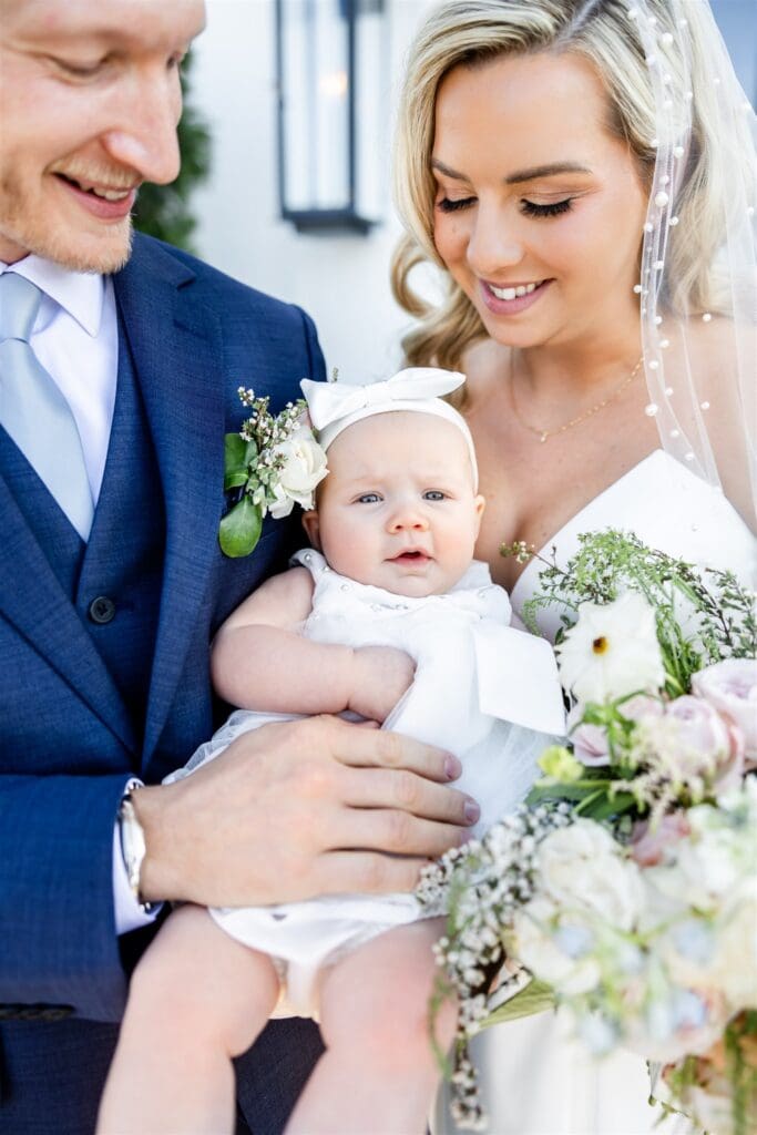 Bride and groom holding their baby
