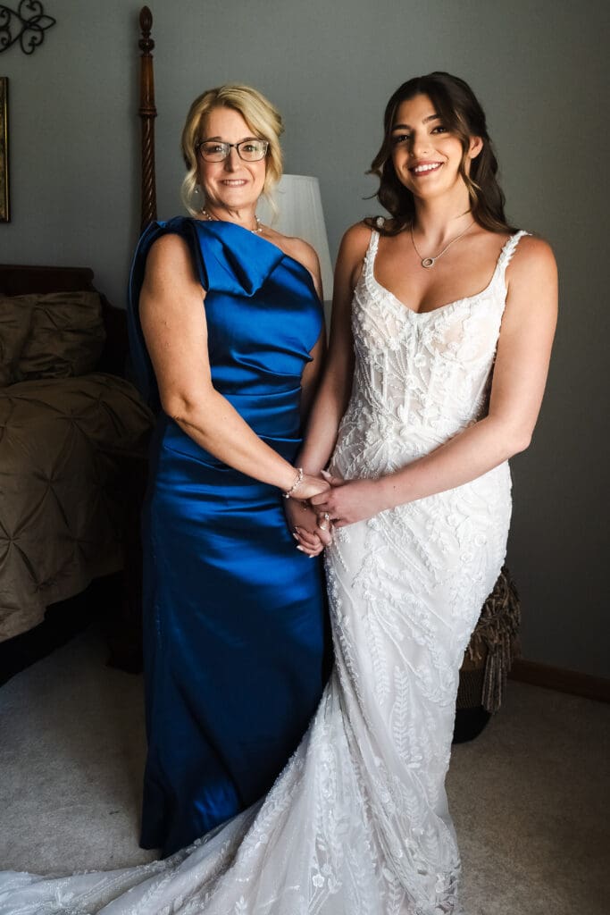 Bride and bride's mom posing for a picture.