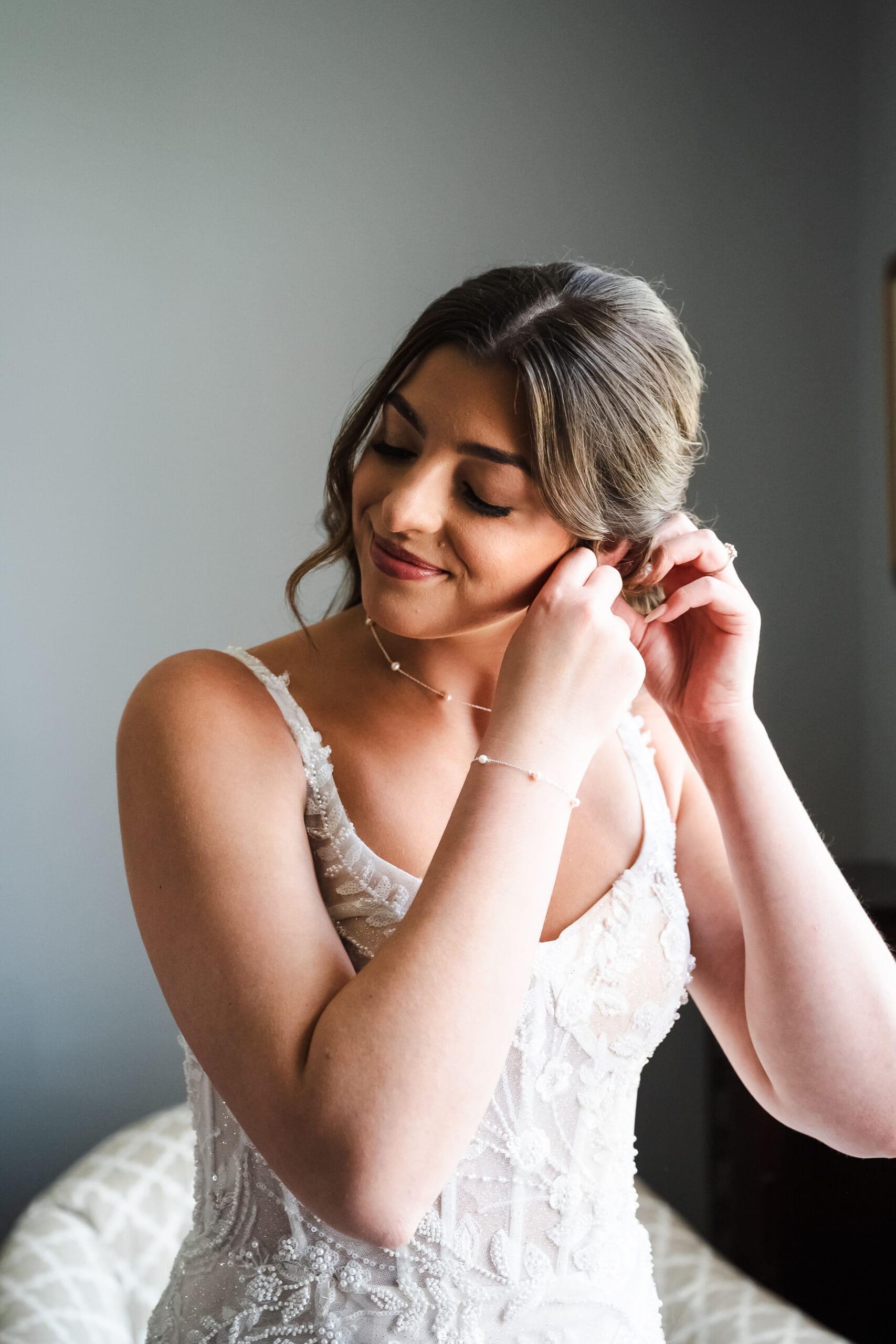 Bride posing and putting on an earring