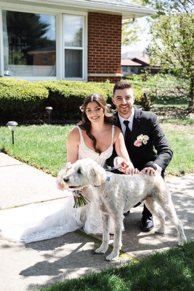 Bride and groom posing with their dog.