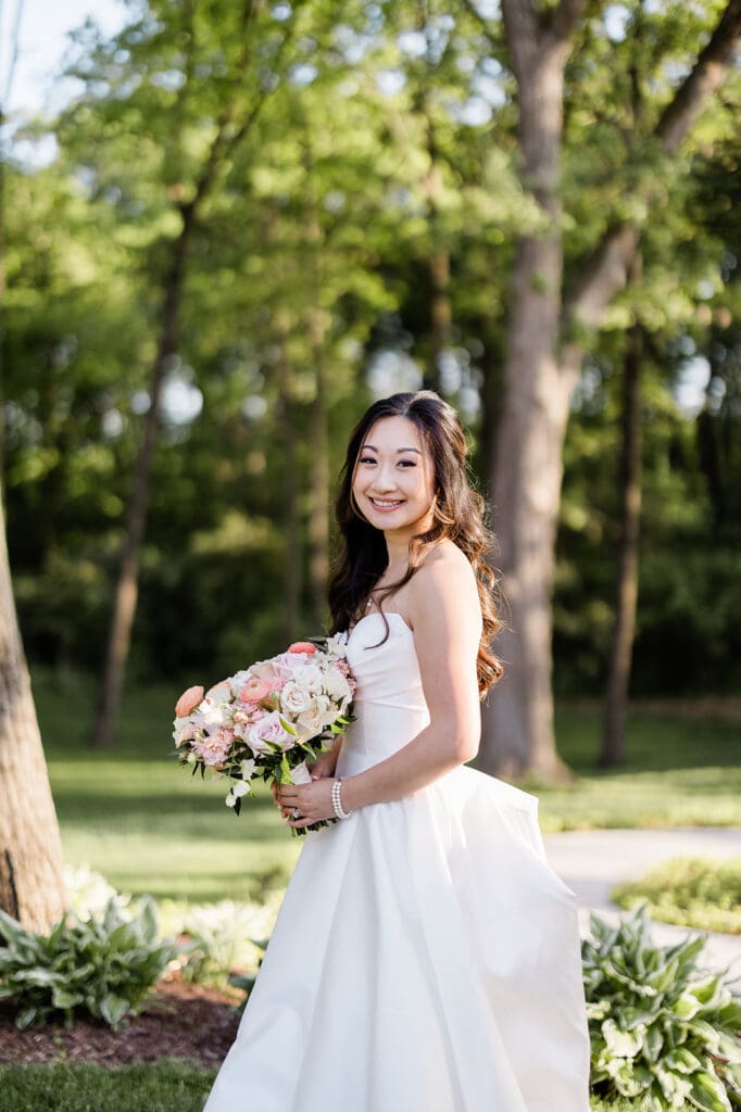 East Asian bride posing for a portrait holding a bouquet