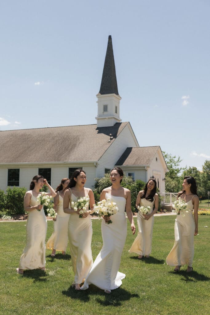 Asian bride and her bridesmaids looking happy and smiling for the camera.