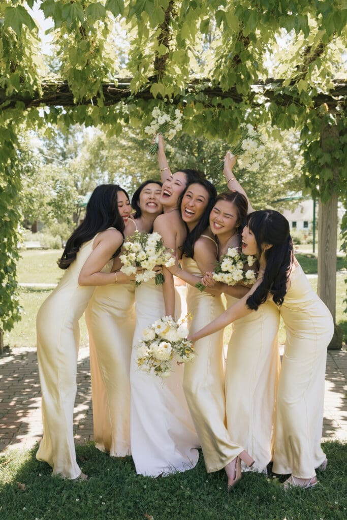 Asian bride and her bridesmaids looking happy and smiling for the camera.
