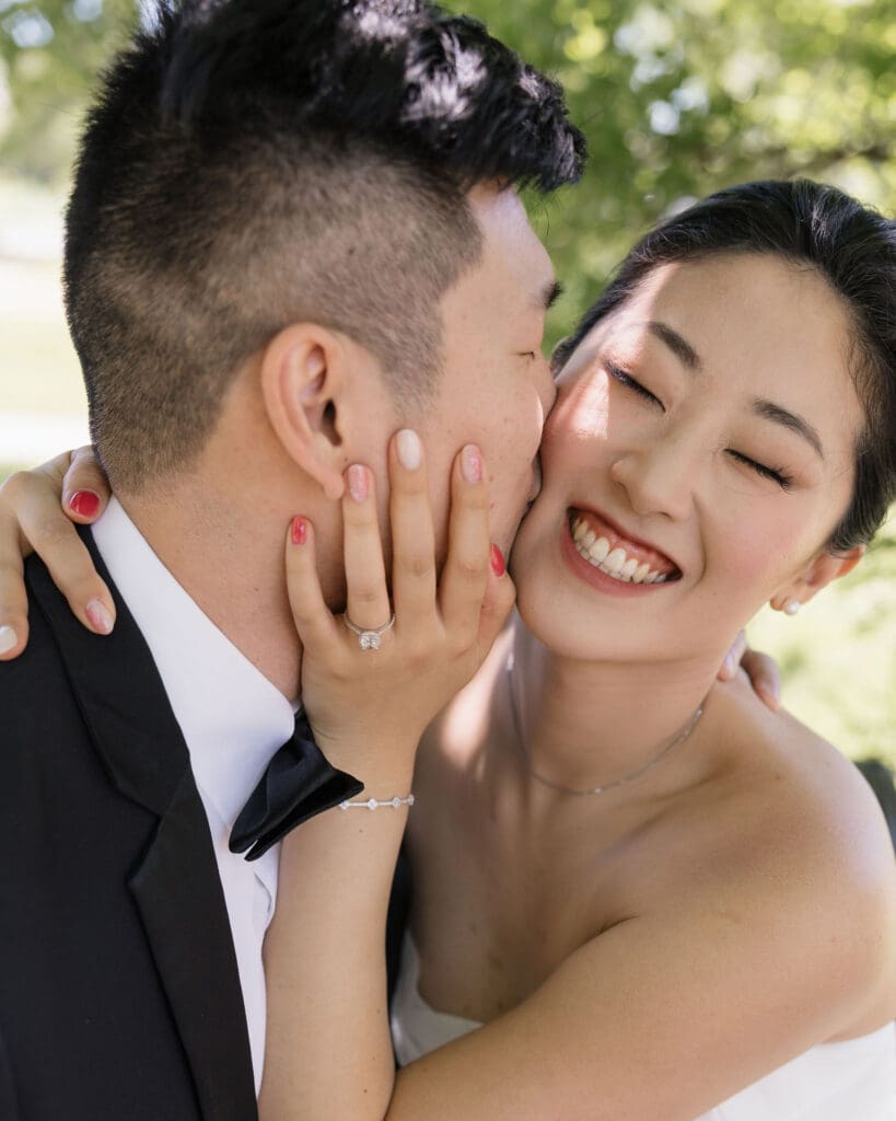 Asian bride and groom kissing the bride on the cheek.