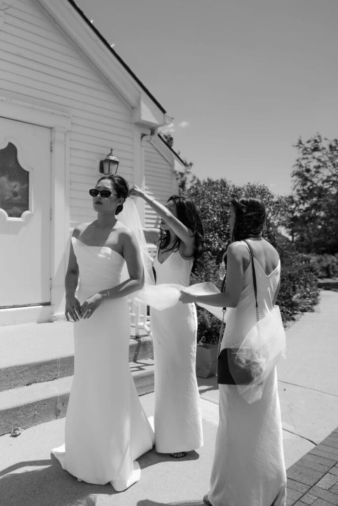 Asian bride and her bridesmaids putting on a veil.