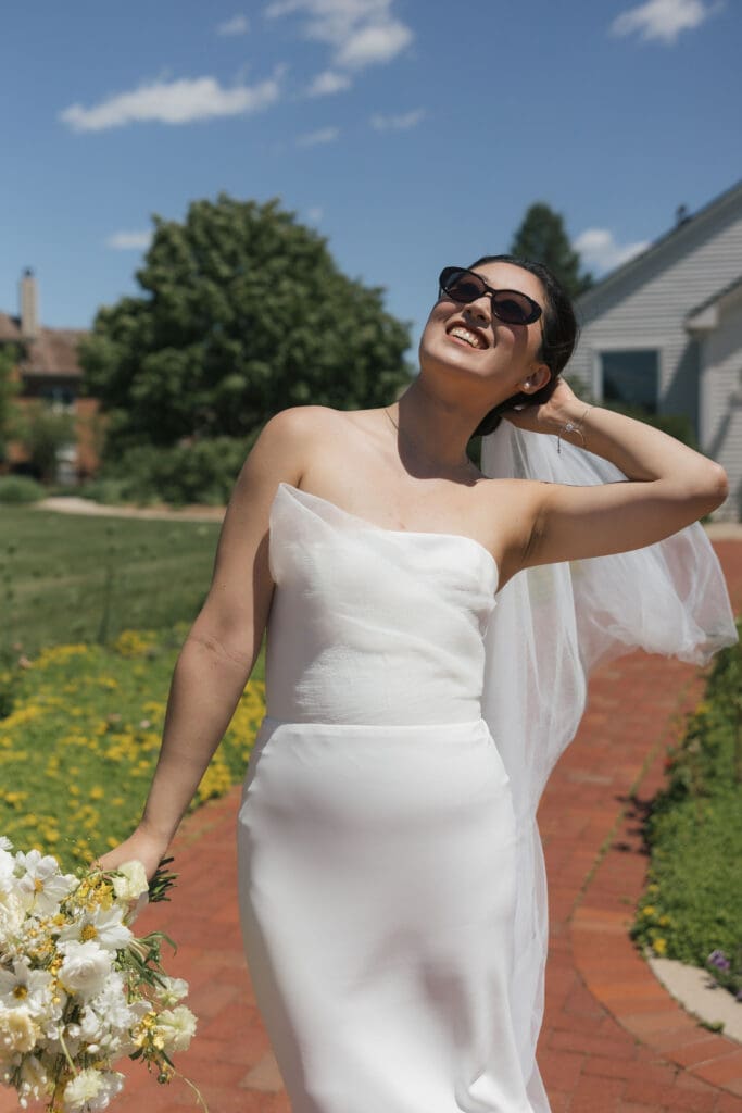 Asian bride holding a bouquet posing for the camera.