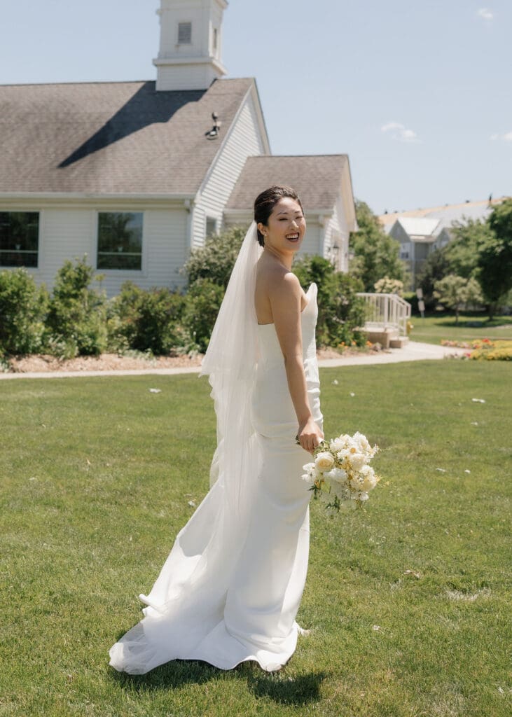 Asian bride holding a bouquet posing for the camera.