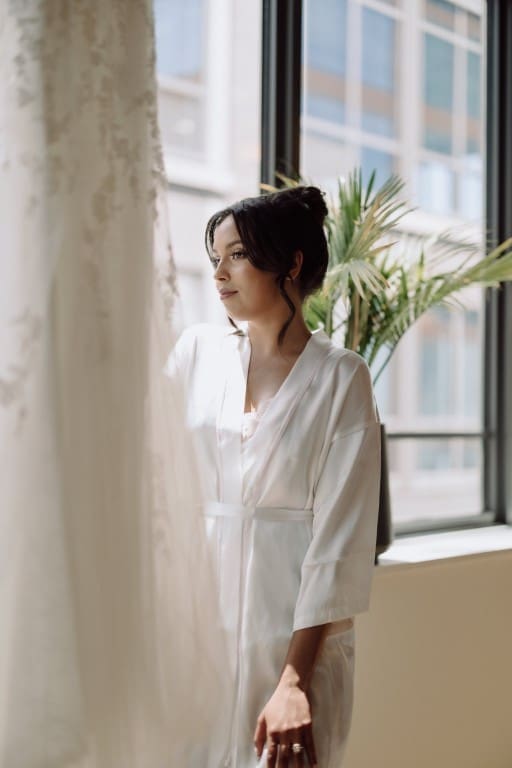 Bride standing in front of a window.