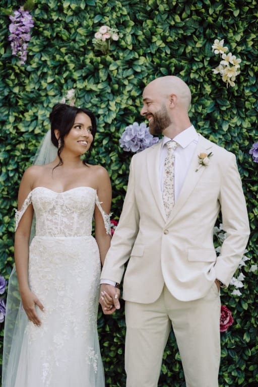 Bride and groom smiling while holding hands.
