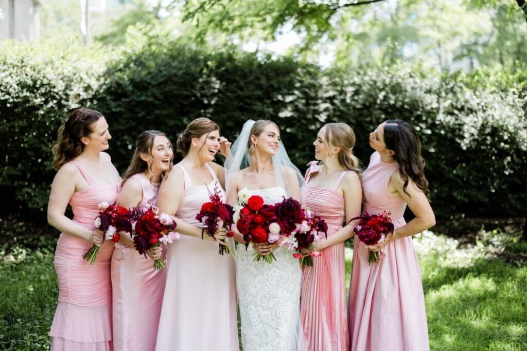 Bride and her bridesmaids holding a bouquet.