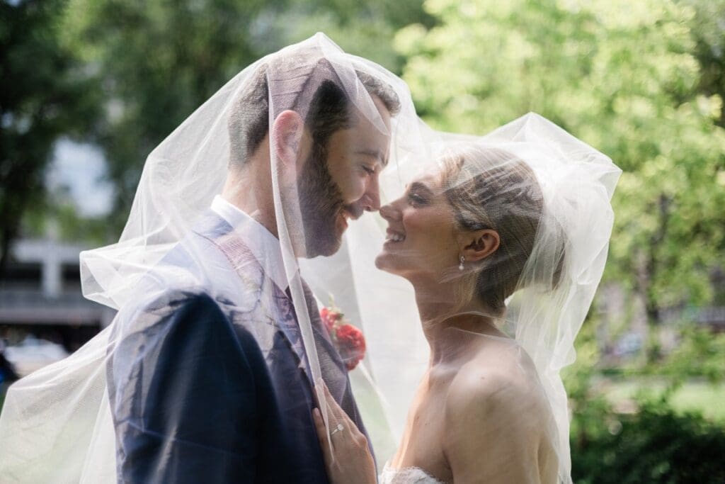Bride and groom under a veil.