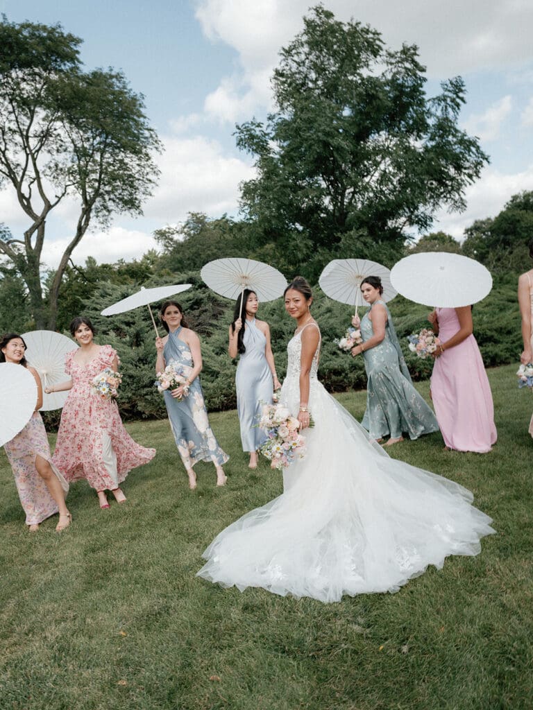 Bride smiling with her bridesmaids, all in coordinated dresses.
