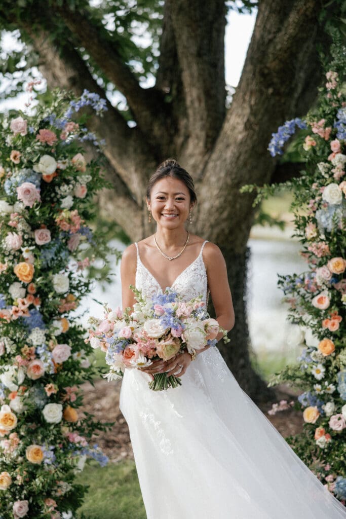 Bride strolling along a garden path, holding her bouquet.