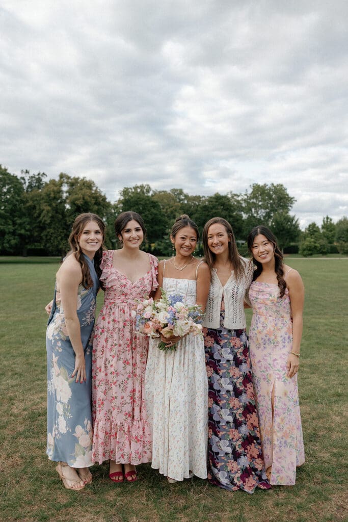 Bride smiling with her bridesmaids, all in coordinated dresses.