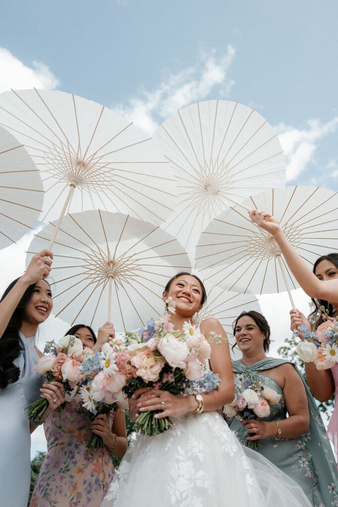 Bride smiling with her bridesmaids, all in coordinated dresses.