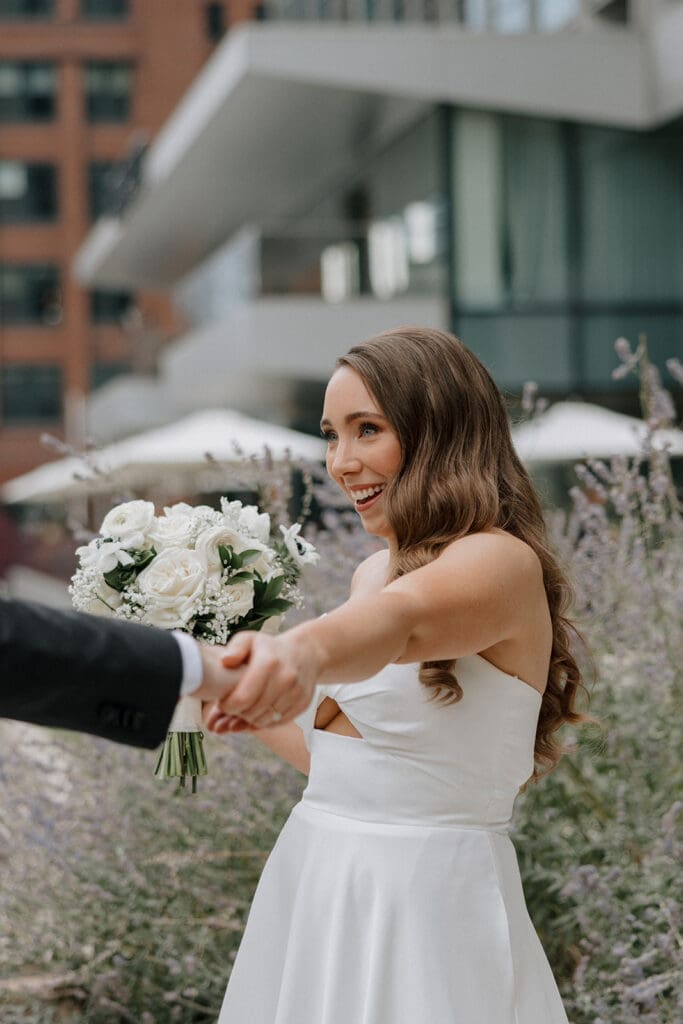 Bride strolling along a garden path, holding her bouquet.
