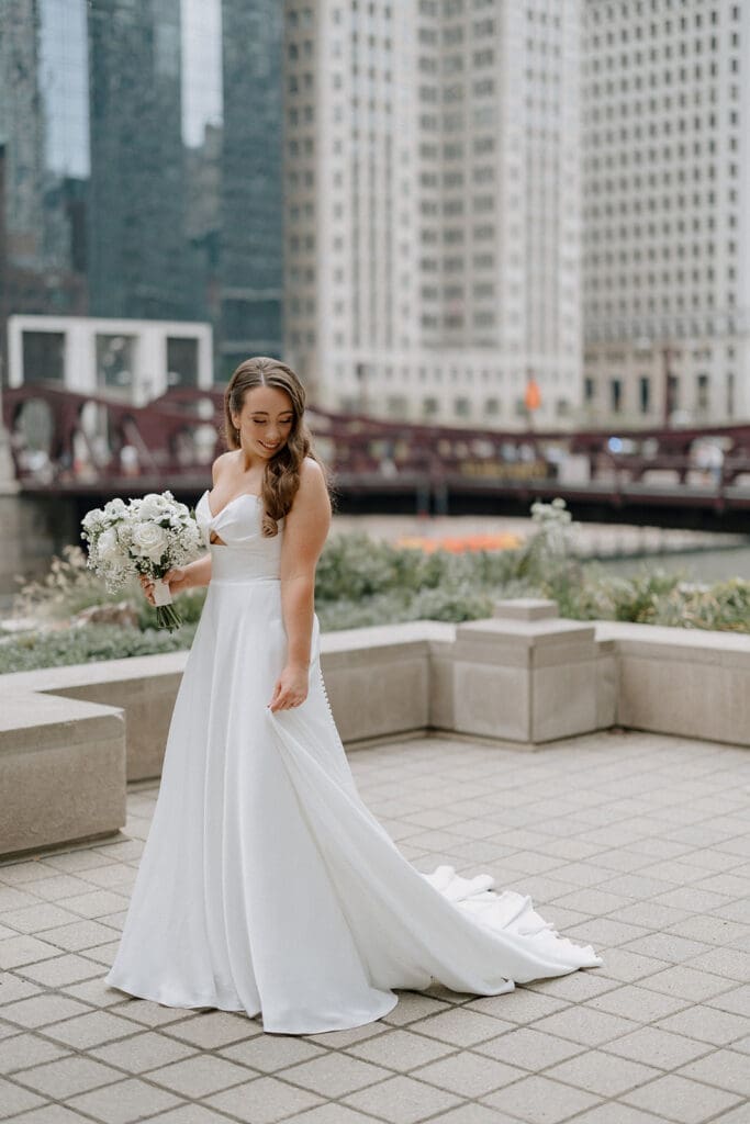 Bride strolling along a garden path, holding her bouquet, with soft sunlight highlighting her dress.
