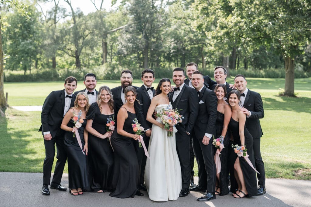 Bride and groom smiling with friends sharing a joyful moment.