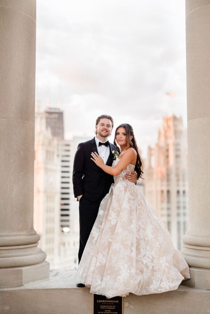 Bride and groom holding hands, smiling at each other on their wedding day.