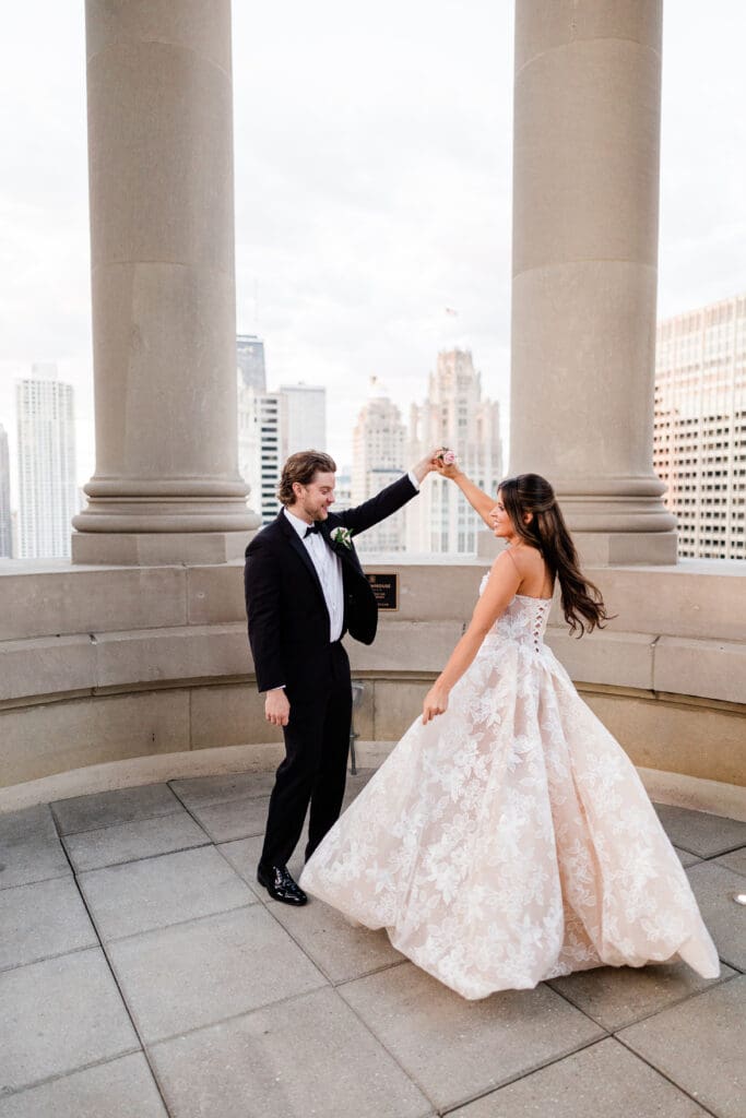Bride and groom holding hands, dancing and smiling at each other on their wedding day.