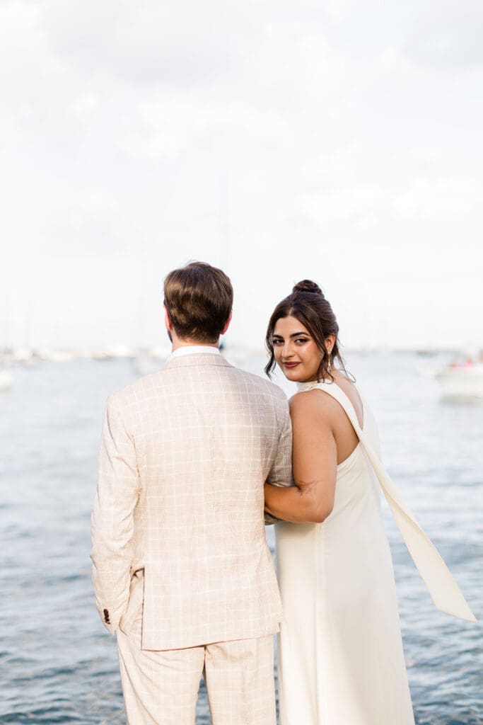 Bride with elegant bridal updo and soft glam makeup smiling at the camera