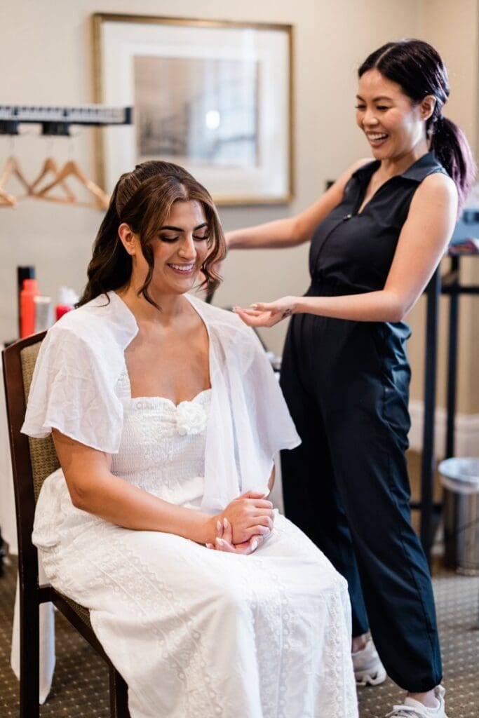 Bride having bridal makeup and hairstyling during wedding morning prep