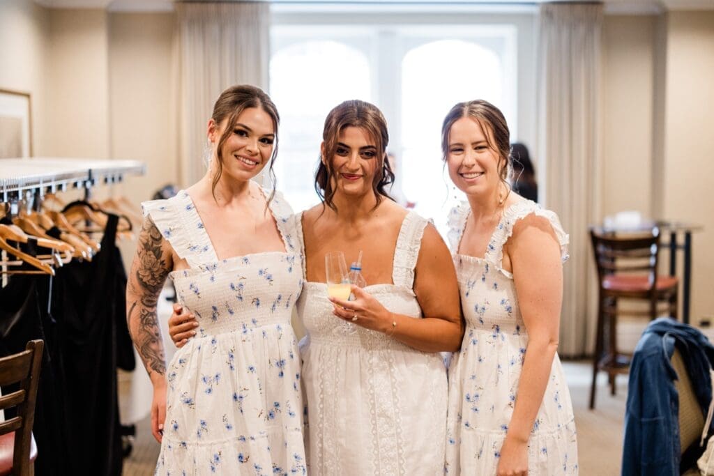 Bride with her bridesmaids smiling at the camera